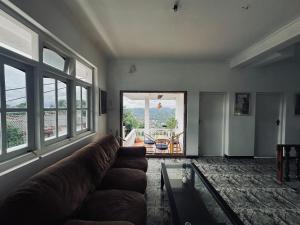 a living room with a couch and a glass table at Cloud Nest Hanthana in Kandy +2 photos