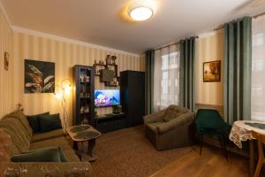 a living room with a couch and a tv at Apartment Amber Riga in Riga