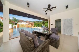 a dining room with a table and chairs and a pool at Villa with Huge Private Pool and Tropical Garden Just 10 Minutes Walk to Kamala Beach in Kamala Beach +55 photos