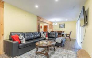 a living room with a black leather couch and a table at Riverview Cottage Escape in Frankford