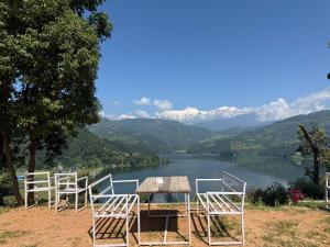 a table and chairs with a view of a lake at Begnas horizon in Pokhara