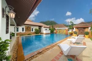 a swimming pool in the backyard of a house at Villa with Huge Private Pool and Tropical Garden Just 10 Minutes Walk to Kamala Beach in Kamala Beach