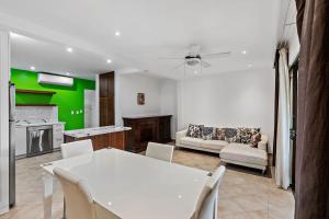 Una cocina y una sala de estar con una mesa y sillas blancas. en Colorful & Private 2-Bedroom Condo Just a Short Walk from the Beach, en Coco