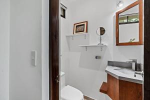 Un baño con lavabo, inodoro y espejo. en Colorful & Private 2-Bedroom Condo Just a Short Walk from the Beach, en Coco
