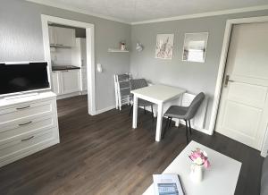 a small living room with a table and a kitchen at Boddenferienhaus - 12 Molenfeuer in Schaprode