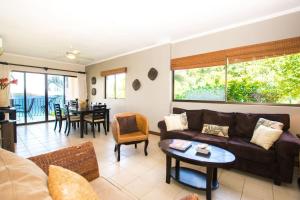 a living room with a couch and a table at Beautiful Condo in Peaceful Cliffside Location with a Private Balcony & Stunning Ocean and Mountain Views in Playa Flamingo