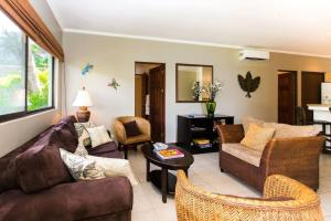 a living room with a couch and chairs and a table at Beautiful Condo in Peaceful Cliffside Location with a Private Balcony & Stunning Ocean and Mountain Views in Playa Flamingo