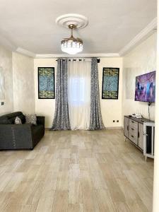 a large living room with a couch and a television at Yoff Oasis Duplex in Dakar