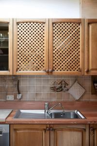 una cucina con lavello e mobili in legno di Mansarda di charm Valli di Borzago a Mortaso