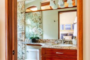 un baño con lavabo y espejo en Spacious Open-Concept Condo with Stylish Design, Direct Beach Access & Resort-Style Amenities, en Playa Flamingo 90 fotos más