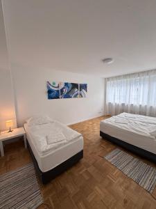 ein Schlafzimmer mit zwei Betten und einem Tisch und einem Fenster in der Unterkunft MonoApartment in Frankfurt am Main