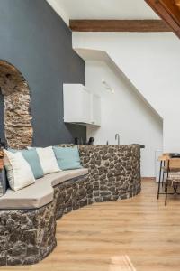 a living room with a stone wall with a couch at Gesuiti Home - Lumina Collection in Catania