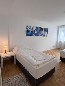 ein Schlafzimmer mit einem Bett, einem Tisch und einem Gemälde in der Unterkunft MonoApartment in Frankfurt am Main