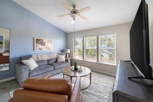 ein Wohnzimmer mit einer Couch und einem Deckenventilator in der Unterkunft Landing Amazing 1BD Tennis Court Gym in Palm Bay