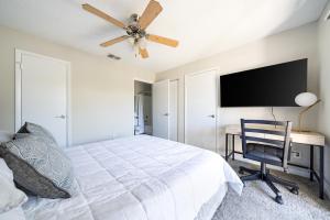 Schlafzimmer mit einem Bett, einem Schreibtisch und einem Deckenventilator in der Unterkunft Landing Amazing 1BD Tennis Court Gym in Palm Bay + 13 Fotos