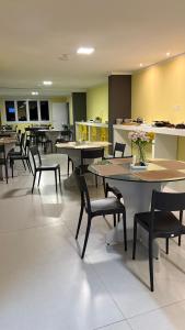 a dining room with tables and chairs and flowers at ÓPER SMART HOTEL in Santa Maria +37 photos