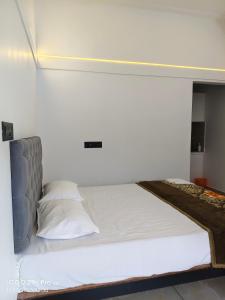 a bed in a room with a white wall at Thazhvaram Pool Villa Idukki Calvary Mount in Idukki +92 photos