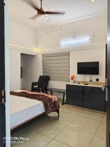 a bedroom with a bed and a desk and a tv at Thazhvaram Pool Resort CalvaryMount in Idukki +72 photos