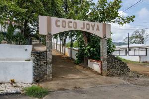 a sign that says coco jyu in front of a building at Tropical Condo with Spectacular Ocean Views, Panoramic Dining Terrace & Quick Walk to Beach in Coco