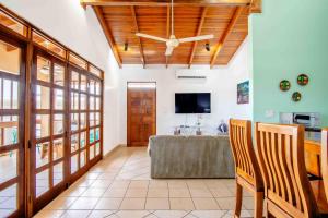 a living room with a table and a ceiling fan at Tropical Condo with Spectacular Ocean Views, Panoramic Dining Terrace & Quick Walk to Beach in Coco