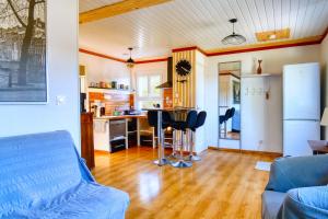 L'HERMITAGE maisonnette lake view beach 5 min walk في Bilieu: غرفة معيشة مع أريكة ومطبخ