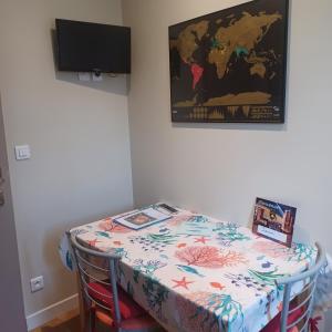 a room with a table with a map on the wall at Apt cosy dans maison de charme in La Rochelle