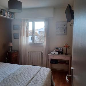 a bedroom with a bed and a window at Apt cosy dans maison de charme in La Rochelle