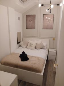 The City Nook في مانشستر: غرفة نوم صغيرة مع سرير مع قبعة سوداء عليه