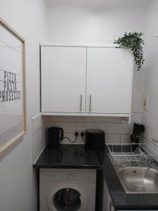 The City Nook في مانشستر: مطبخ مع حوض وغسالة ملابس