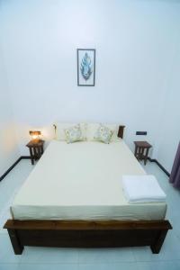 a large bed in a room with two tables at Villa Vows in Tangalle