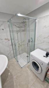 a shower with a washing machine in a bathroom at Drazdiak House Antolska Lake View in Bratislava
