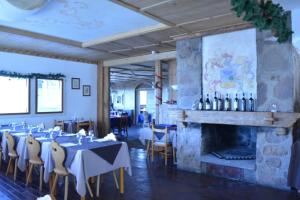una sala da pranzo con tavoli e sedie e un camino di Eurotel Cermis a Cavalese