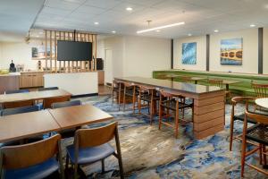 a conference room with tables and chairs and a tv at Fairfield Inn & Suites by Marriott Frederick in Frederick