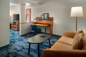 a hotel room with a desk and a couch at Fairfield Inn & Suites by Marriott Frederick in Frederick