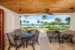 Un patio con mesa y sillas y vista al mar. en Upscale Two-Bedroom Condo in Playa Flamingo with Beautiful Oceanfront Views, en Playa Flamingo