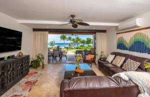 Una sala de estar con un sofá y un televisor en Upscale Two-Bedroom Condo in Playa Flamingo with Beautiful Oceanfront Views, en Playa Flamingo