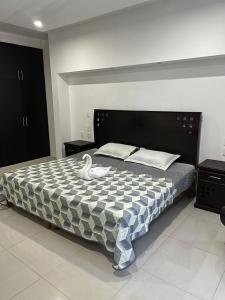 Un dormitorio con una cama con un cisne encima. en Casa Hannia 30 huéspedes Cerca de la playa Alberca, en Acapulco 18 fotos más