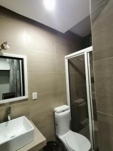 Un baño con inodoro, lavabo y espejo. en Casa Hannia 30 huéspedes Cerca de la playa Alberca, en Acapulco