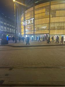 um grupo de pessoas caminhando em frente a um prédio em Hendham House em Manchester