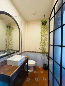 a bathroom with a sink and a toilet and a mirror at Hotel Tulum Centro, Party Hotel in Tulum +31 photos