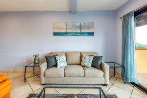 a living room with a couch and a glass table at 2-Bedroom Condo with Ocean View and Pool in Playa Flamingo