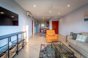 a living room with a couch and a table at 2-Bedroom Condo with Ocean View and Pool in Playa Flamingo