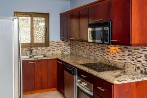 a kitchen with a microwave and a stove top oven at 2-Bedroom Condo with Ocean View and Pool in Playa Flamingo