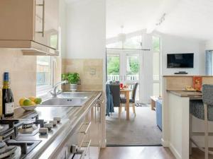 eine Küche mit Spüle und Herd in der Unterkunft Merley Woodland Signature 2 Lodge with Hot Tub in Wimborne Minster