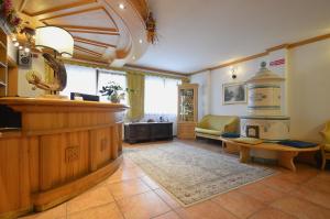 a large room with a counter and a living room at Hotel Villa Fosine Spa & Wellness in Pinzolo