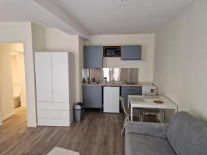 Una pequeña cocina con una mesa y un sofá. en Studio Hyper Centre Libourne, en Libourne