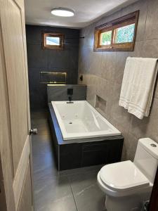 a bathroom with a white tub and a toilet at Cabañas villa de San Miguel in Huasca de Ocampo