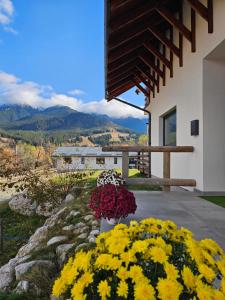 um ramo de flores em um quintal ao lado de um edifício em Panoramic Chalet Bran em Bran