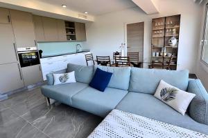 a living room with a blue couch and a kitchen at Superb penthouse swimming pools equipped solarium panoramic view in Xeresa