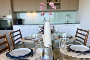 a dining room table with glasses and a vase with flowers at Superb penthouse swimming pools equipped solarium panoramic view in Xeresa +67 photos